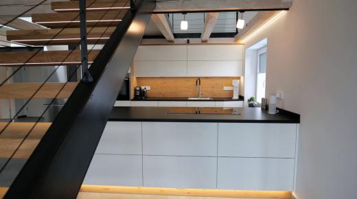 Moderne Einbauküche in weiß mit schwarzer Arbeitsplatte 